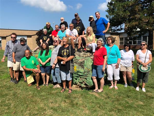 Members of the R-H Class of 1968 stand in front of the rock at Roth